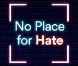 'No Place for Hate' neon text on a blue brick background