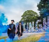 Graduates celebrating in front of the Nottingham sign